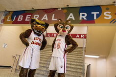 IUPUI mascots Jawz and Jazzy pose in front of Liberal Arts signage.